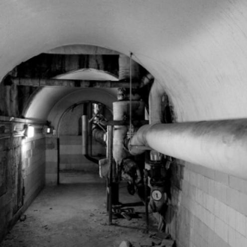 Tunnel med rundbuet loft og et kraftigt vandrør.